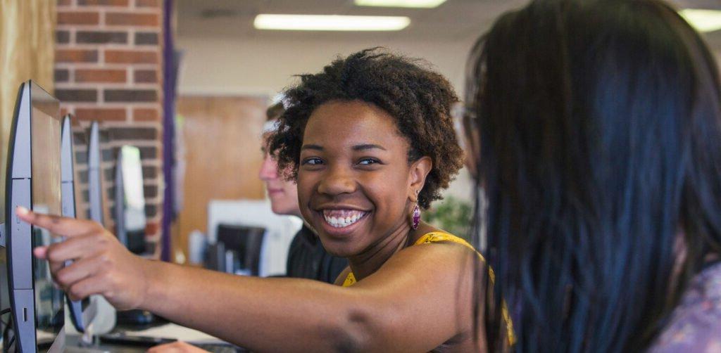 HSU student pointing to computer screen and talking to her classmate