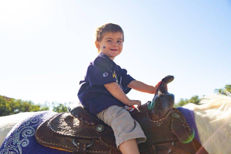 Little boy at homecoming during a Six White Horse ride.